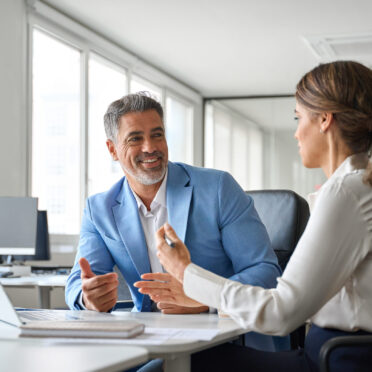 Two older executives team business people man and woman working at office corporate meeting. Happy mature business woman professional bank manager lawyer consulting client on finances management